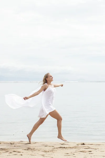 Hübsche Frau läuft am Strand — Stockfoto