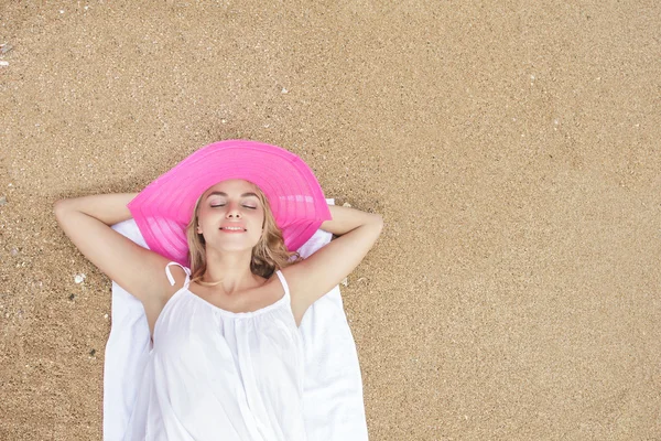 Krásná žena ležící na písku — Stock fotografie