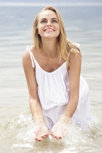 Frau spielt Wasser am Strand — Stockfoto