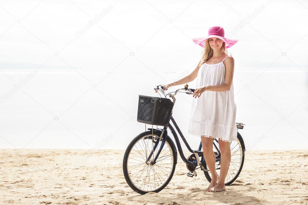 woman standing with bicycle on beach