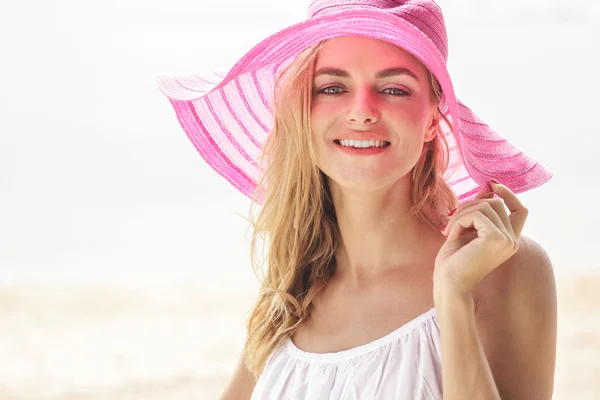 Donna in cappello da sole rosa sulla spiaggia — Foto Stock