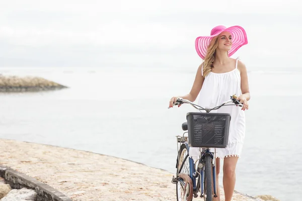 ビーチで自転車と一緒に歩いている女性 — ストック写真