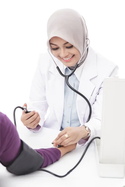 Asiática médico feminino verificando a pressão arterial de um paciente — Fotografia de Stock