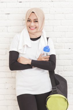 Sportif Asyalı duvara yaslanmış 