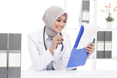 Asyalı kadın doktor stetoskop bir not okuma ile