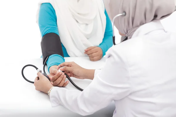 Médico feminino verificando a pressão arterial de um paciente — Fotografia de Stock