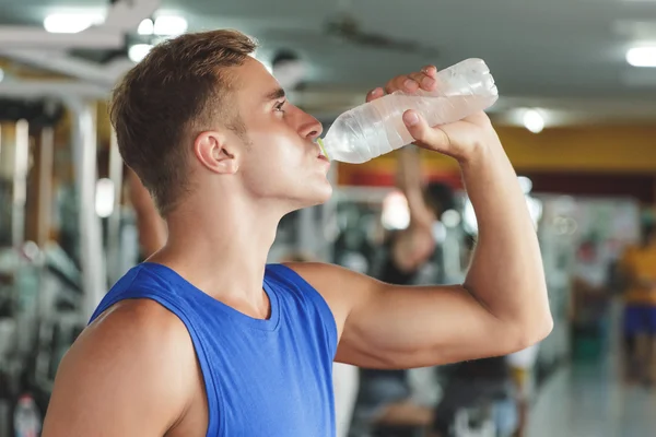 Man mineraalwater drinken op sportschool — Stockfoto