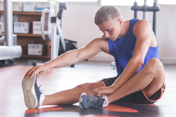 Man uitrekkende voeten op sportschool — Stockfoto