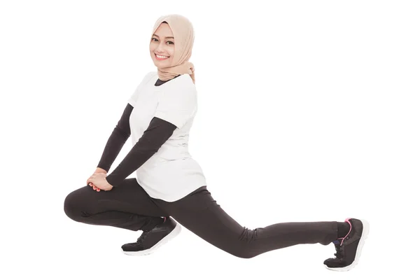 Muslimische sportliche Frau macht Beinstreckung — Stockfoto