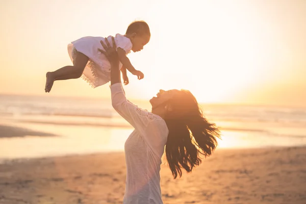 Madre con el bebé contra la puesta del sol —  Fotos de Stock