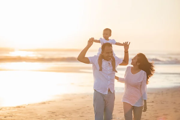 Famille heureuse et bébé profitant du coucher de soleil — Photo