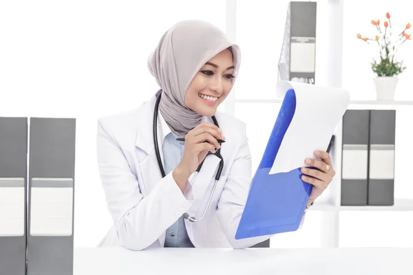 Asiatique femme médecin avec stéthoscope lecture une note — Photo