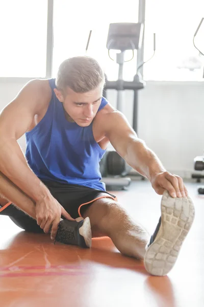 Hombre estirar los pies en el gimnasio — Foto de Stock