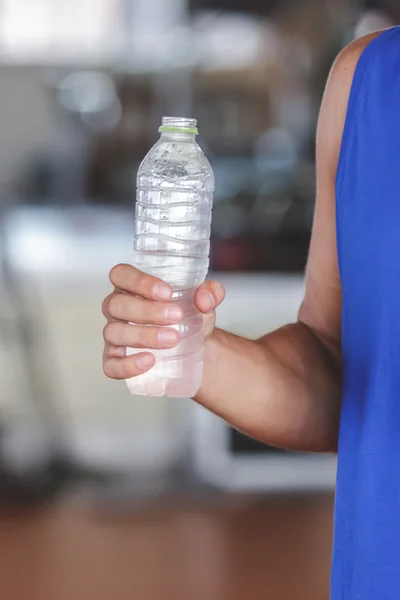 Strong hand holding a bottle of mineral water — Stock Photo, Image