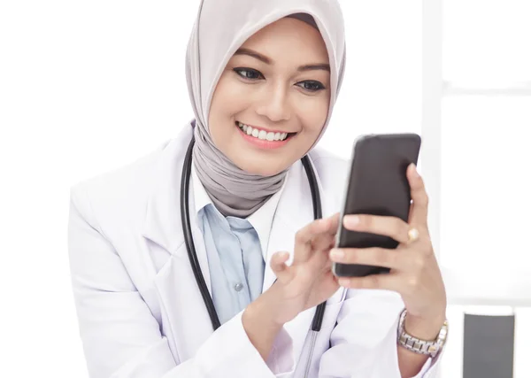 Красивая азиатская женщина врач с помощью мобильного телефона — стоковое фото
