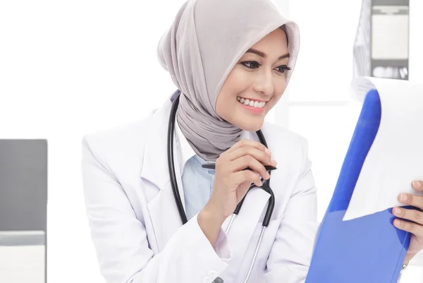 Asiático médico femenino con estetoscopio leyendo una nota —  Fotos de Stock