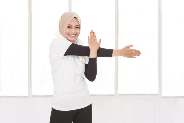 Frau beim Dehnen der Hand beim Lächeln — Stockfoto