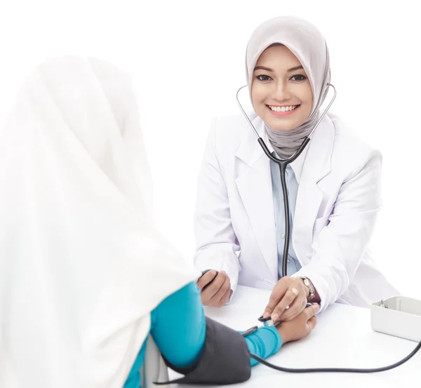Asiática médico feminino verificando a pressão arterial de um paciente — Fotografia de Stock