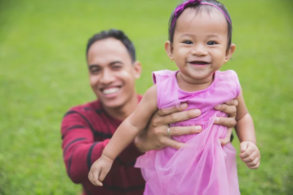 Отец держит маленькую дочь на руках — стоковое фото
