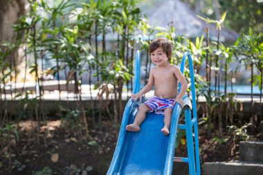 Çocuk slayt üzerinde kayar