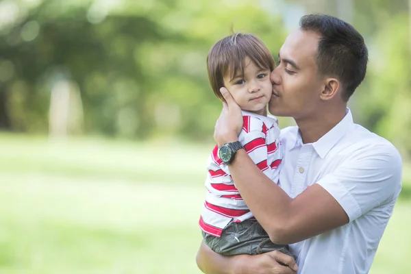 Vader omarmen en kussen lachende baby — Stockfoto