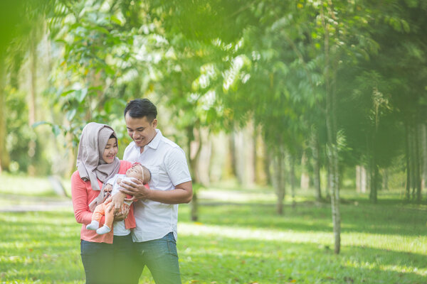 мать и отец с новорожденным ребенком в парке
