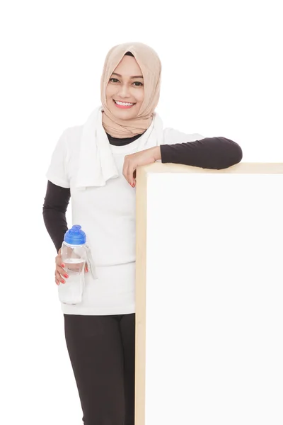 Мусульманская спортсменка держит в руках бутылку минеральной воды — стоковое фото