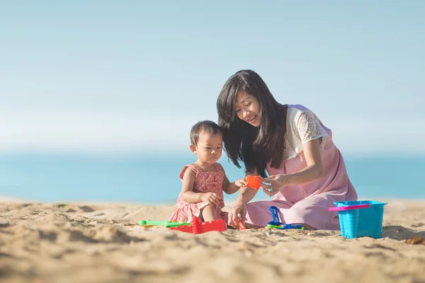 Bébé fille avec mère à la plage — Photo