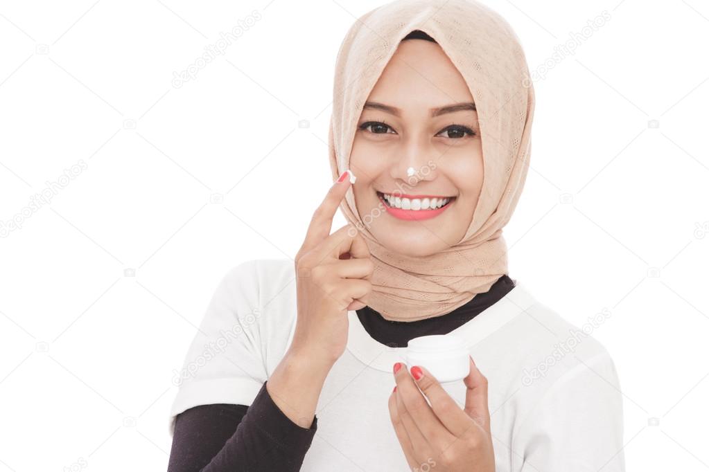 beautiful asian woman using moisturizer cream for face skin care