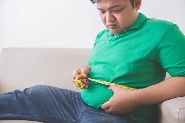 Gros homme mesurant son ventre à la maison — Photo