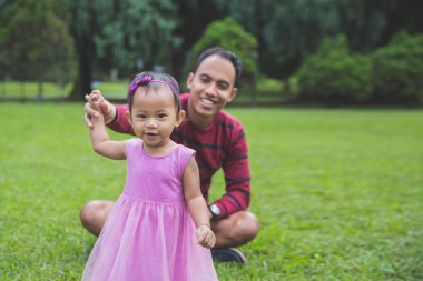 mutlu bebek yeşil çimenlerin üzerinde ilk adımlarını yapma