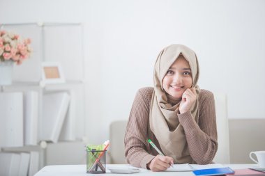 bir şeyler yazıyor başörtüsü ile güzel Asyalı kadın