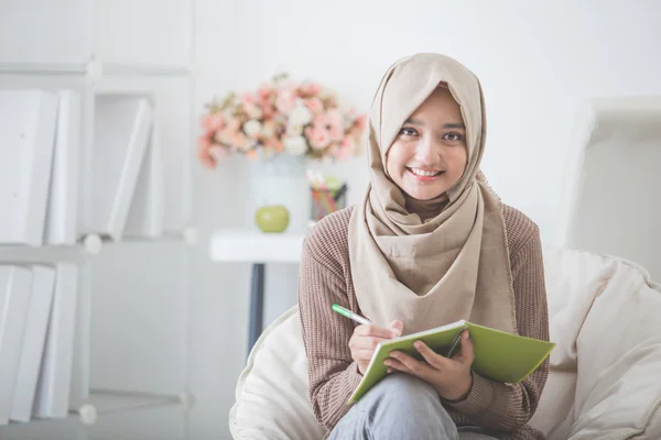 Hermosa mujer asiática con cabeza bufanda escritura algo — Foto de Stock