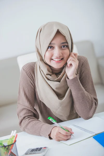 Gyönyörű ázsiai diáklány hidzsáb csinál házi feladatot a — Stock Fotó