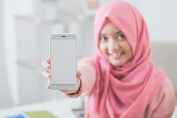 Mulher mostrando tela do telefone móvel e sorriso para a câmera — Fotografia de Stock