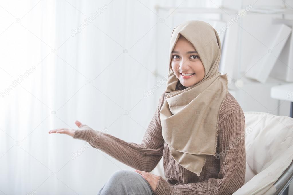 attractive young woman smiling presenting to copy space