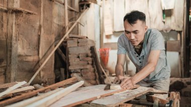 Ön manzara marangozu tahta kesiyor daire şeklinde testere kullanıyor.