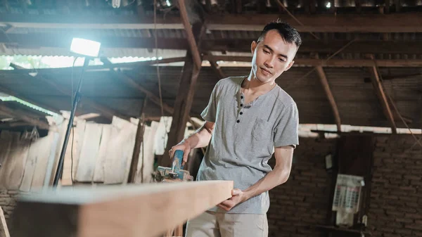 Carpinteros asiáticos trabajan en tacos eléctricos de madera y observan superficies de madera rugosa — Foto de Stock