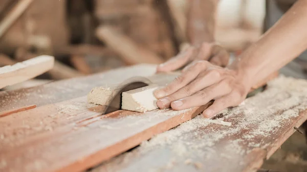 Nahaufnahme eines Tischlers, der mit einer Kreissäge Holzbohlen von Hand schneidet — Stockfoto