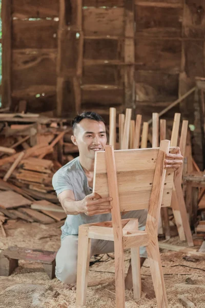 Азиатские плотники работают, устанавливая спинки деревянных стульев — стоковое фото