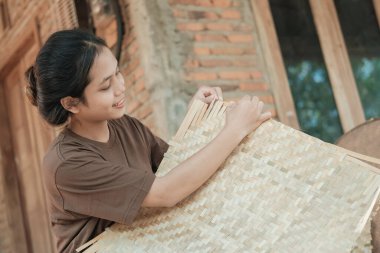 Bambu hasırları yaparken gülümseyen kadın işçilerin yan görünüşü