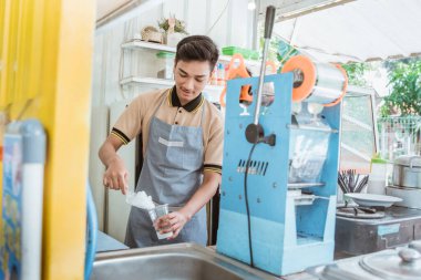 Bir adam buz küpü döküyor. Küçük dükkan satıcısı