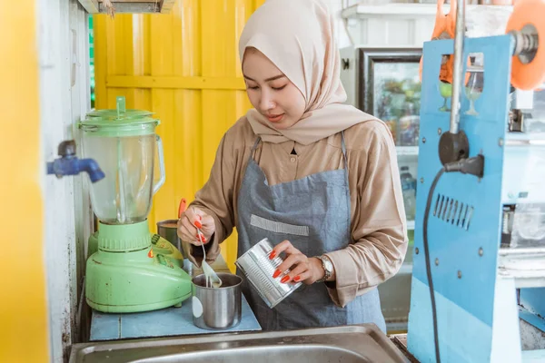 Eine Frau schenkt eine Milch ein — Stockfoto