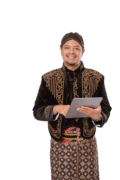 Portrait of a happy traditional Javanese man holding a tablet. — Stock Photo, Image