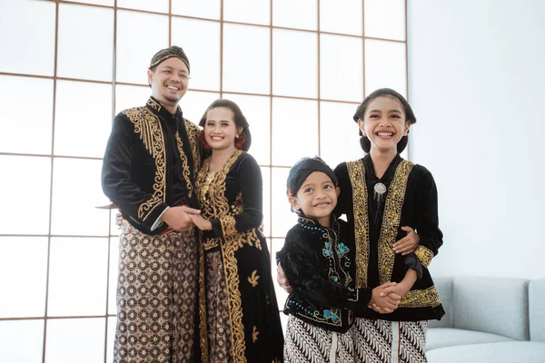 Portrait of a happy family wearing traditional Javanese clothes. — Stock Photo, Image