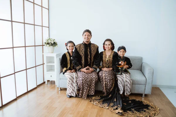 Portrait of a happy family wearing traditional Javanese clothes. — Stock Photo, Image