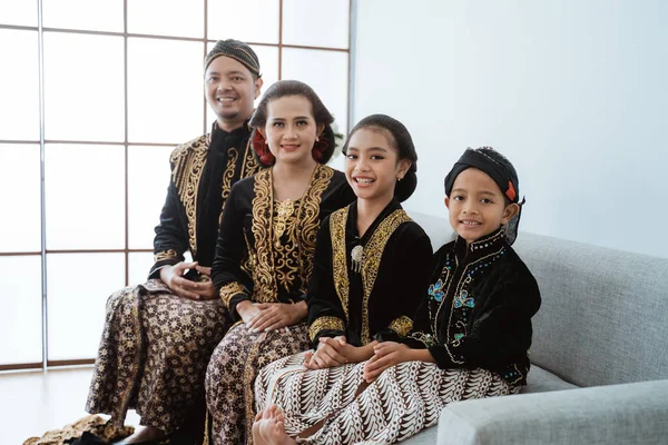 Retrato de uma família feliz vestindo roupas tradicionais javanesas. — Fotografia de Stock