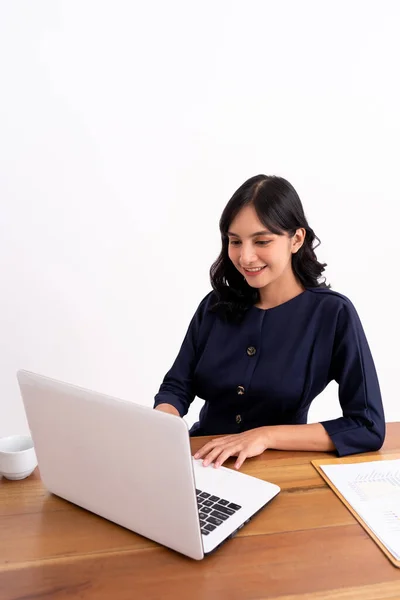 Aantrekkelijke vrolijke jonge zakenvrouw werken op laptop en glimlachen tijdens het zitten. — Stockfoto