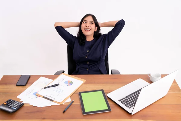 An attractive and cheerful young business woman is stretching and smiling as she sits up. — Stock Photo, Image