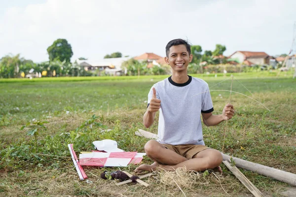 Ein junger Mann bereitet einen Bambusstock zu — Stockfoto
